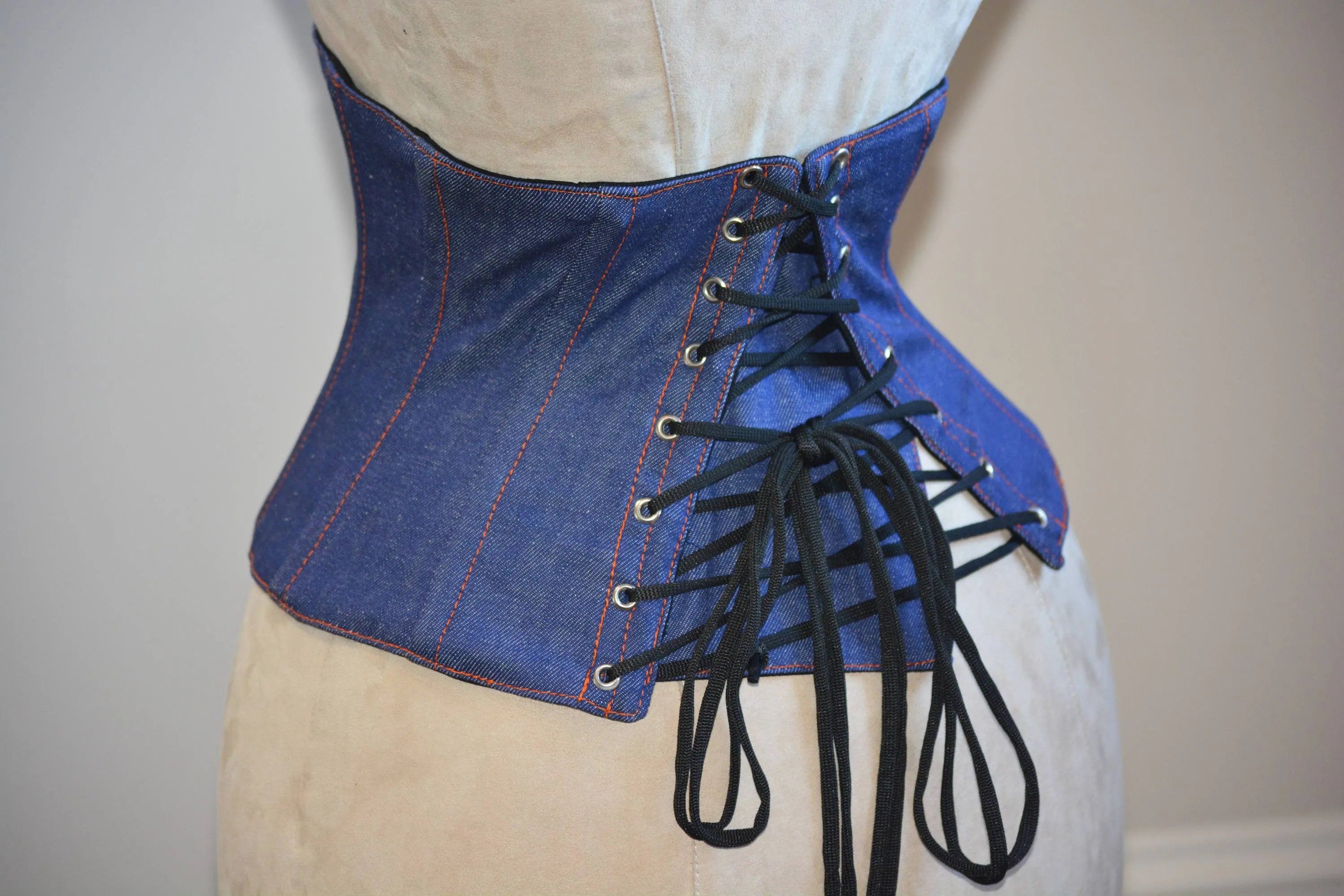 Trendy waspie belt corset from denim. Waist training fitness edition corset belt with laces in front, trendy summer corset